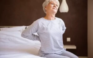 Elderly Woman Sat On Bed With Lower Back Pain V2 400x250 1